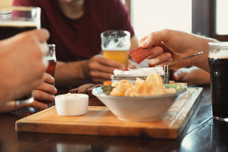 朋友在酒吧里喝啤酒和吃零食图片