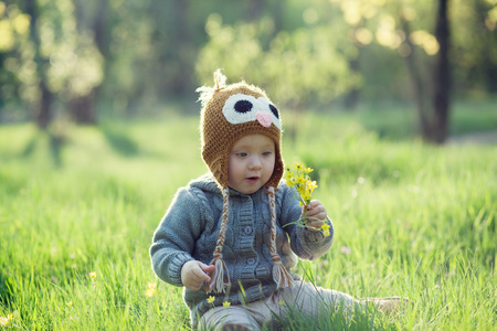 可爱的小宝宝针织服装在花园里玩