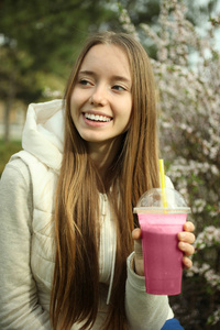 一个女孩在喝粉红色的冰沙