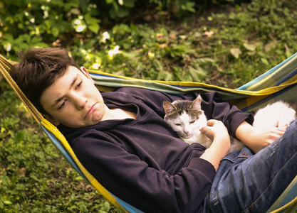 少年男孩与猫在圆丘圆丘午睡