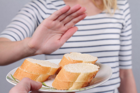 麸质不容忍和饮食概念。女人不肯吃白面包。在面包上的选择性焦点