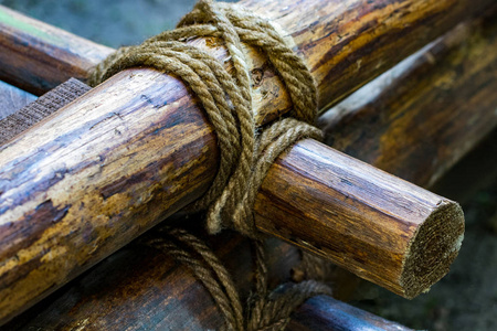 把绳子系在木头上。把绳子拴在棍子上。把绳子拴在木头上