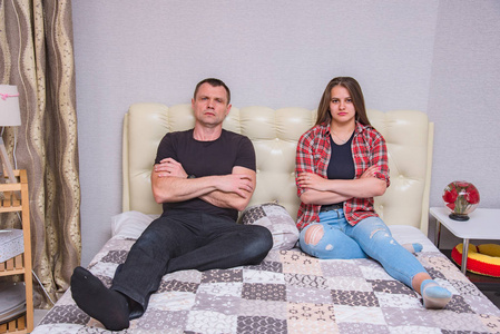 父亲和女儿的肖像与家庭问题, 家庭困难的家庭关系在床上的房间。他们就在镜头前, 看起来不开心。