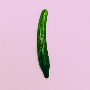 粉红色的背景上的新鲜黄瓜.最小的时尚风格照片