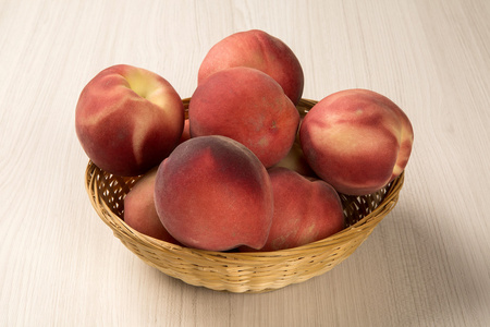 一些在木质表面上的篮子里的桃子