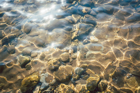 水中的卵石在地中海鹅卵石海滩清澈的水中的石头照片