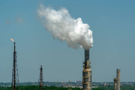 蓝天上的炼油厂烟雾背景吸烟烟囱