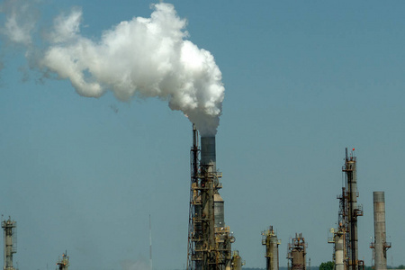 蓝天上的炼油厂烟雾背景吸烟烟囱