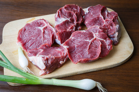 葱切菜板的生牛肉片图片