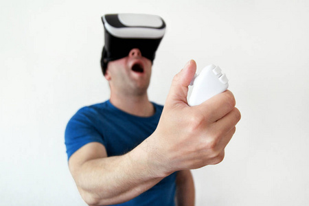 男子穿着和玩手机游戏应用程序在设备虚拟现实玻璃上的白色背景。男子行动和使用虚拟耳机, Vr 框, 用于智能手机。当代技术理念