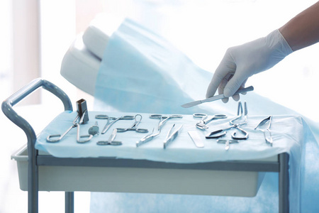 外科医生的手以柳叶刀护士在手术中给医生一个工具.