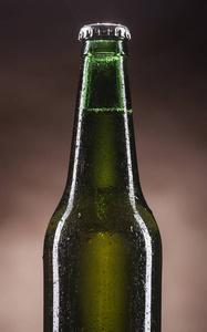 玻璃瓶装的啤酒上棕色背景图片