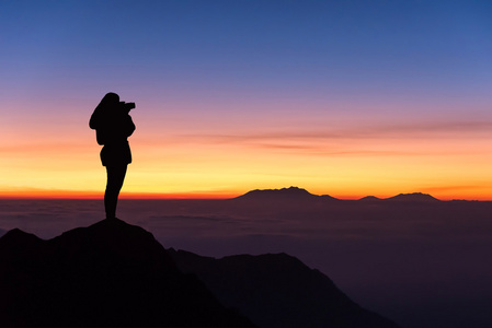 女人拍照山顶的轮廓和