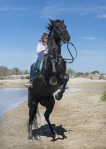 女人骑着她的种马在沙滩上照片
