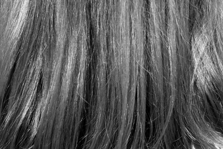 女人的头发在阳光下黑白相间.设计的抽象背景和纹理照片