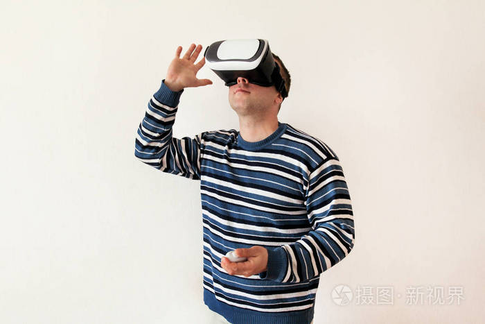 男子穿着和玩手机游戏应用程序在设备虚拟现实玻璃上的白色背景。男子行动和使用虚拟耳机, Vr 框, 用于智能手机。当代技术理念