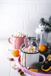 两杯热巧克力或可可粉与融化的棉花糖, 菠萝锥, 云杉树枝和普通话托盘上的白色木背景