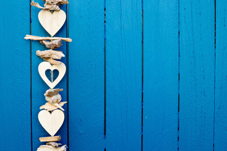 背景蓝色的栅栏上挂着的装饰漂移木心