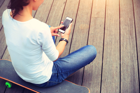 女滑板使用智能手机