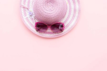 沙滩配件, 包括海星, 粉红色太阳镜和紫色沙滩帽在青色纸背景下的暑假和假期概念