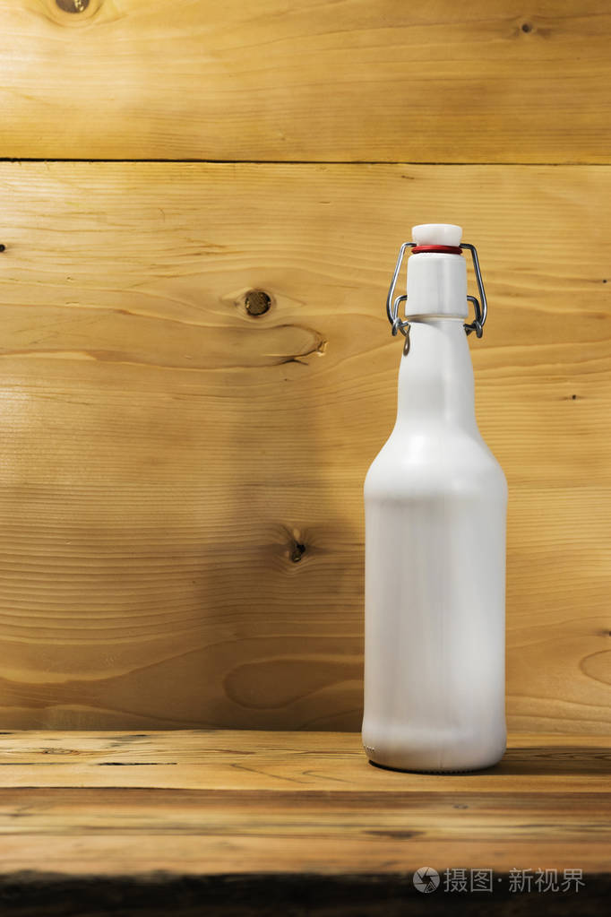 在木制橡木桌上放一瓶啤酒的玻璃瓶.美丽的新木质背景