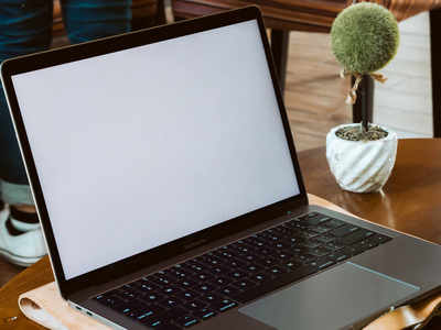 咖啡咖啡厅桌上的白色空屏幕笔记本电脑