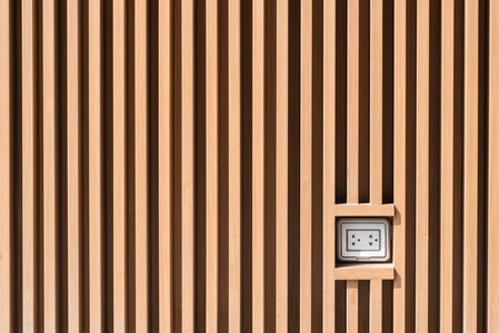 上光棕色木墙上的图案，在室外安装插头插座