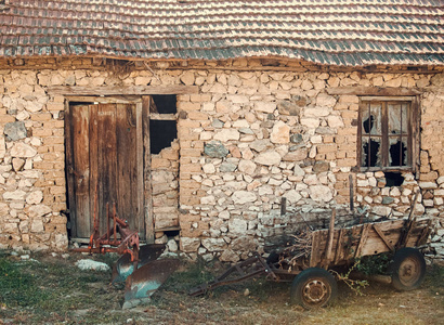 无人居住的房子废弃的车旁边的废墟.旧车靠近石墙.