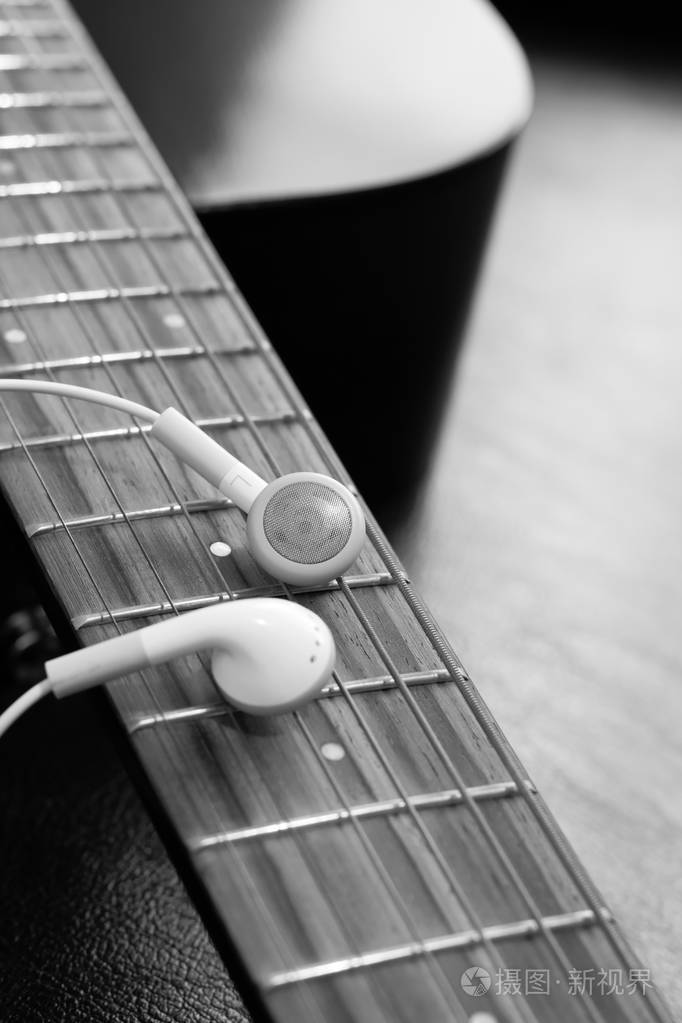 原声吉他指板上的白色耳机