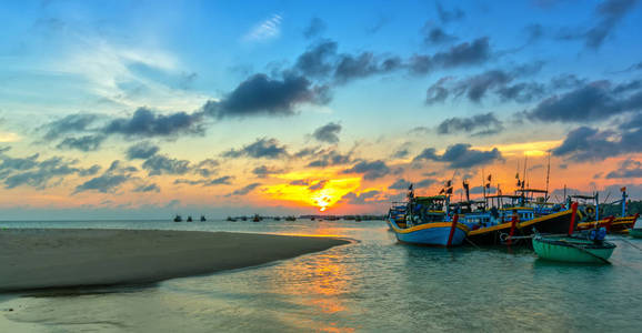 夕阳和小船在海面上缓缓的在地平线上盘旋, 在海湾上创造出美丽的金色光芒。这是伟大的田园风光在这里