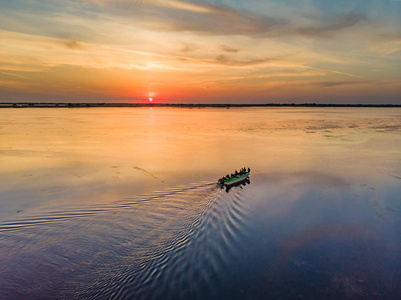 游客们在日落时乘船游览多瑙河三角洲。日落在多瑙河三角洲 三角洲 Dunarii, 欧洲, 罗马尼亚