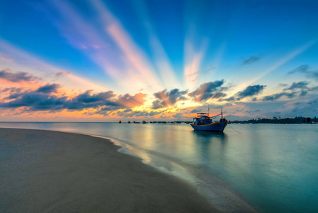 夕阳和小船在海面上缓缓的在地平线上盘旋, 在海湾上创造出美丽的金色光芒。这是伟大的田园风光在这里