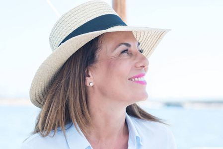 美丽的中年妇女在帆船上旅行和微笑的快乐和自信照片