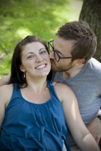 男人亲吻脸颊上的女孩高级的女人和狗母亲和女儿躺在一起外面的草地上