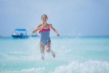 穿泳装的女孩在热带海滩上玩得开心