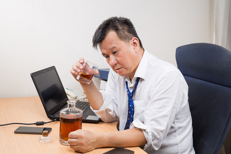 在办公室喝烈性酒的沮丧和压力亚洲经理