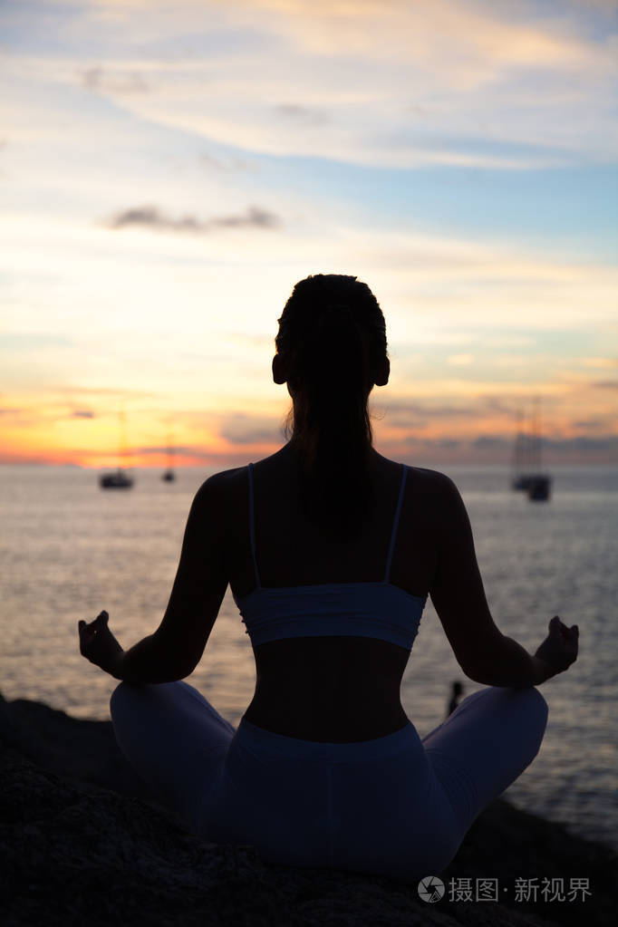 在海滩上的瑜伽姿势打坐的女人