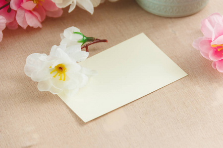 与鲜花花束白色木制背景上空白贺卡