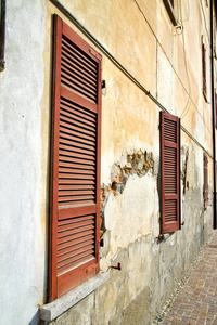 意大利抽象阳光灿烂的日子的红色窗口瓦 borghi 宫殿木百叶帘在混凝土砖