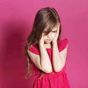 8岁的小女孩在粉红色的中性背景下, 用手做一些情绪化的手势.