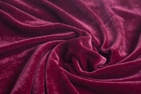 褐色的天鹅绒红色天鹅绒面料与螺旋褶皱特写照片