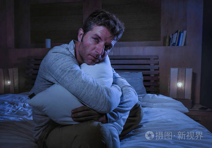 年轻的悲伤和绝望的人醒着深夜在床上在黑暗中遭受压抑和焦虑寻找压力