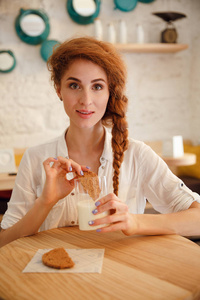 坐在咖啡馆的漂亮微笑红发女子肖像