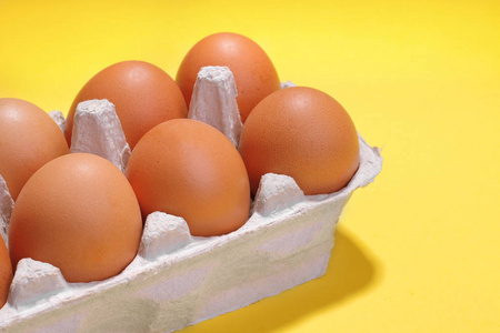 褐色鸡蛋在盘子里为蛋在明亮的黄色背景