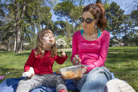 孩子和母亲在公园里吃面食