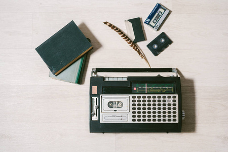 旧的磁带录音机, 书籍和羽毛。顶部视图。layflat
