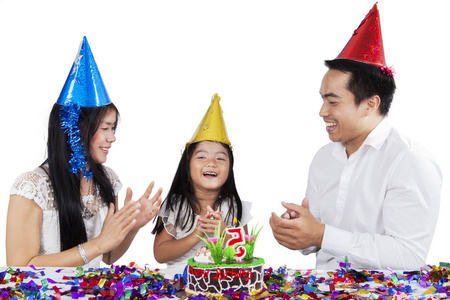 可爱的小女孩庆祝生日聚会与她的父母, 在白色背景孤立的图片