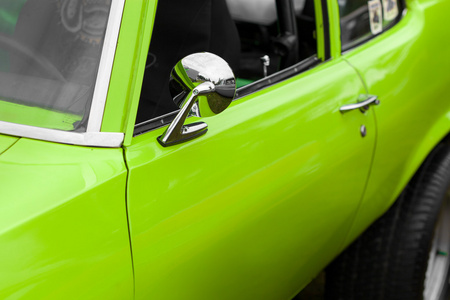 一辆绿色的老式汽车的后视镜