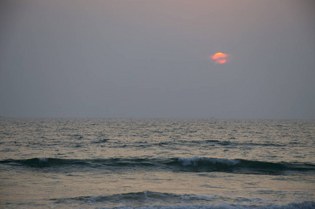 美丽的风景日落与在海蓝色与红色太阳和波浪
