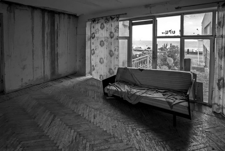 废弃的凌乱的房间.旧沙发在废弃的房子里.黑白摄影照片